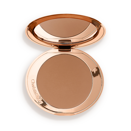 An open mirrored-lid bronzer compact in a medium-brown shade. 