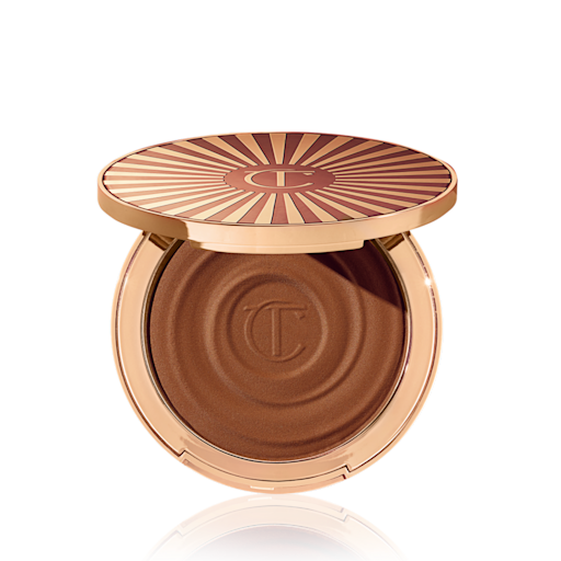 Poudrier de bronzer crème ouvert, de couleur marron foncé, dans un emballage doré.